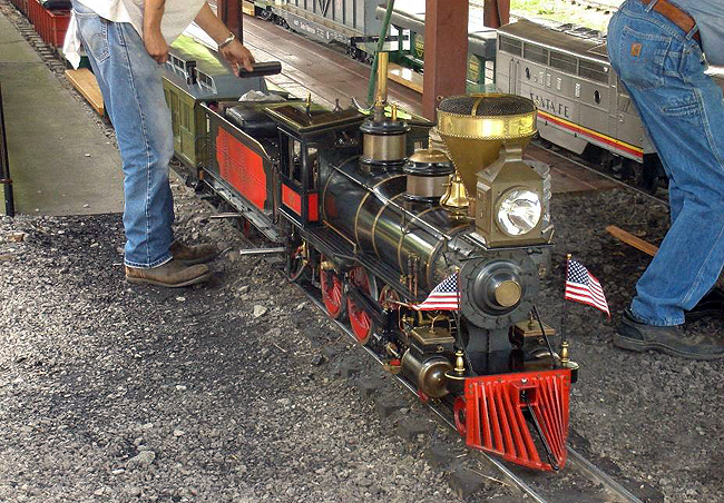 A beautiful 1/8 scale 4-4-0 American type gets a little attention during a station stop at Hesston Junction before departing with the next scheduled “advertised”.  Although the full-scale Shay was in the shop on this day, this little 15-horsepower steam locomotive puts on quite a show for the crowd at the Hesston Steam Museum. 