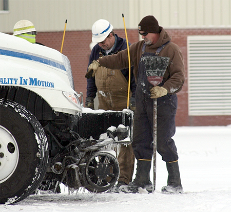 A cold CSX crew works to get a highrail vehicle on the tracks at West Broadway crossing in Madisonville, Wednesday, January 28, day two of the storm.