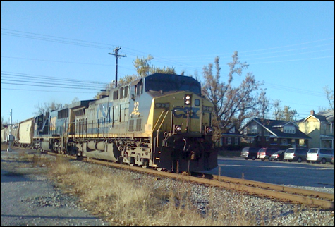 You got to love the bright blue November sky in Kentucky!  I caught this north bound in Madisonville one morning after dropping Liam off for School at West Broadway, Madisonville.  A couple of the old homes in the background are supposedly scheduled for demolition.  Just imagine the trains they’ve seen and the whistles they’ve heard. -Bill Thomas